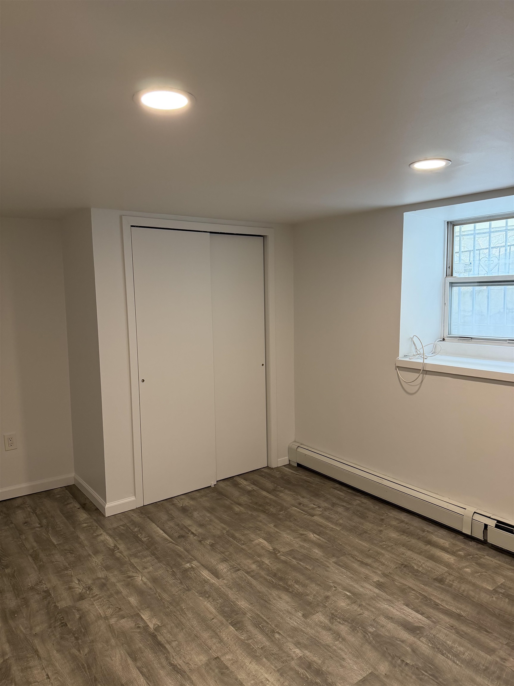 290 Paterson Plank Road, Unit 1 Jersey City, NJ 07307 - Photo 15 of 17 an empty room with wooden floor and windows
