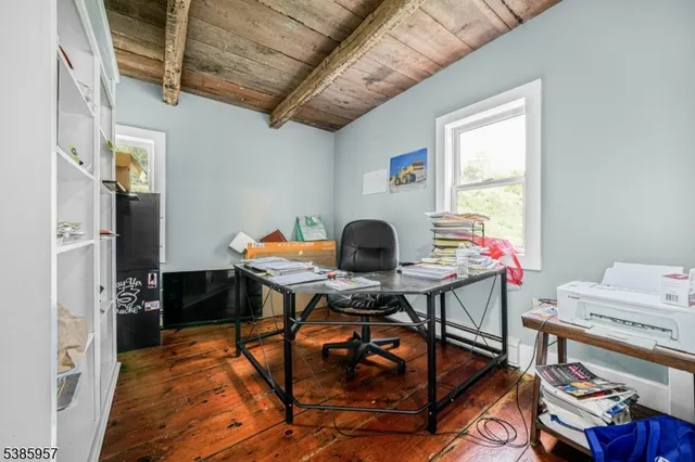 a view of a hallway with wooden floor and entryway