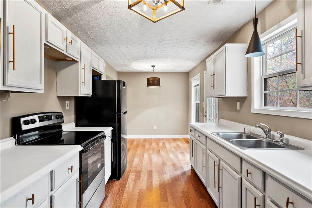 42 Crow Court Monticello, GA 31064 - Photo 12 of 33 a kitchen with granite countertop a sink a stove and refrigerator