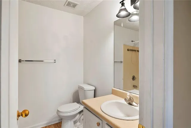 a bathroom with a toilet a sink and mirror