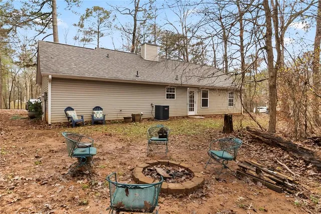a view of a backyard with table and chairs and barbeque grill