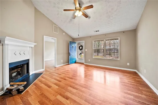 a view of an empty room with a fireplace and a window