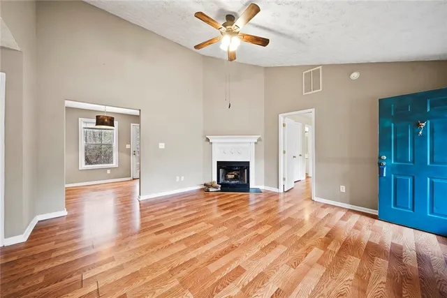 a view of an empty room with window and fire place