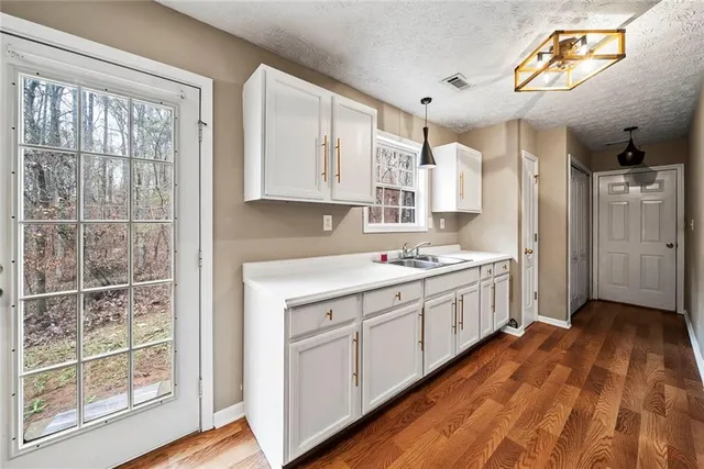a kitchen with a sink cabinets stainless steel appliances and a window