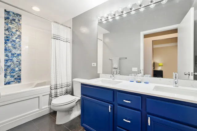 a bathroom with a toilet a sink and a large mirror