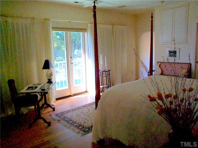 6097 Bob Daniel Road Oxford, NC 27565 - Photo 10 of 24 a bedroom with a bed and a chandelier