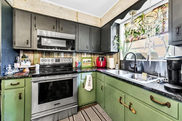 a kitchen with stainless steel appliances granite countertop a sink cabinets and a wooden floor