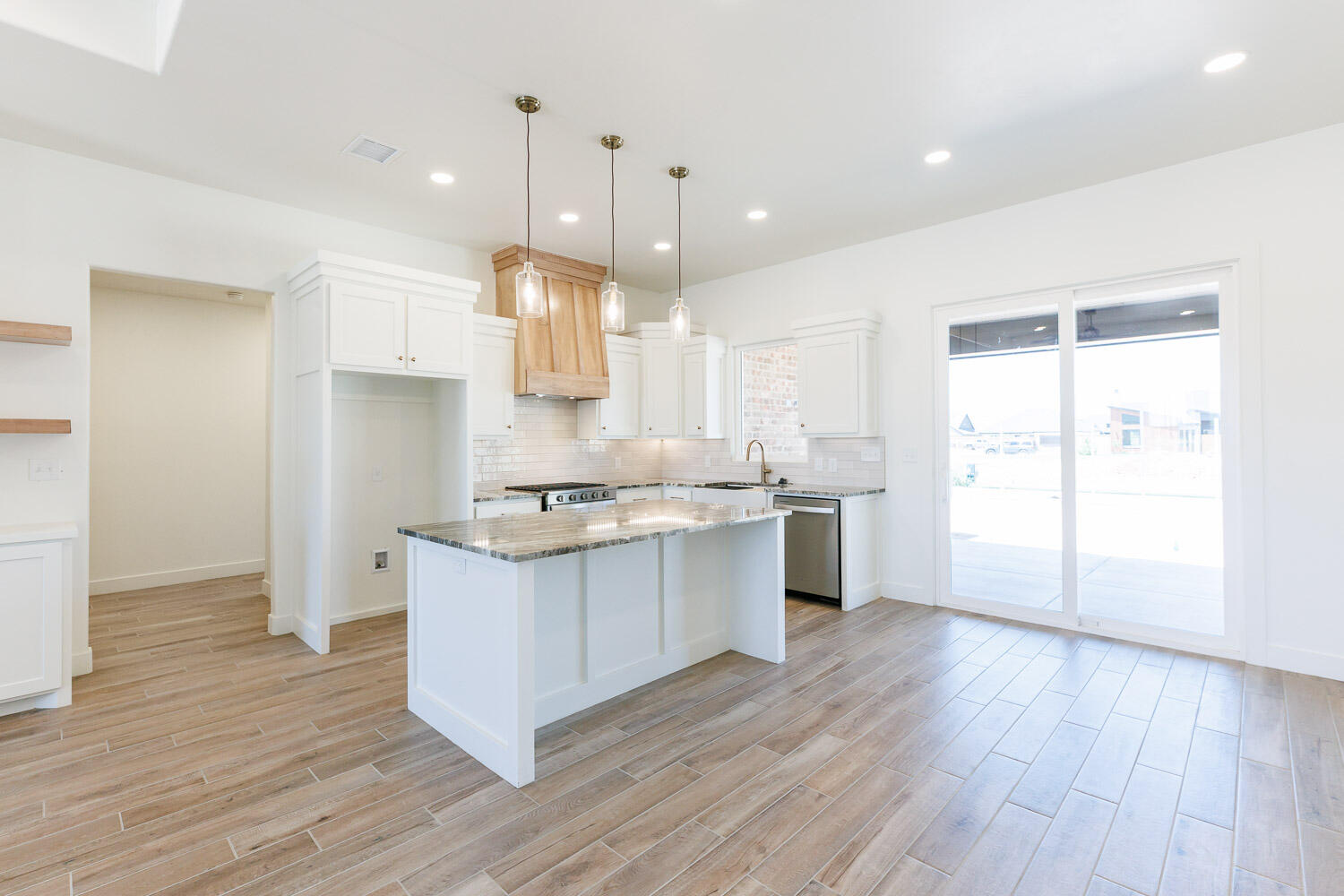 3634 144th Street Lubbock, TX 79423 - Photo 13 of 55 a kitchen with stainless steel appliances granite countertop a sink a stove a refrigerator and white cabinets with wooden floor