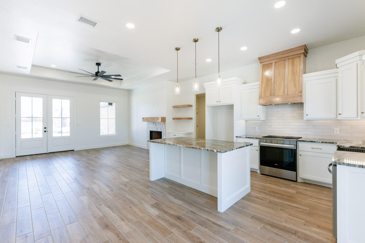 3634 144th Street Lubbock, TX 79423 - Photo 14 of 55 a large kitchen with stainless steel appliances granite countertop a stove a sink and a wooden floors