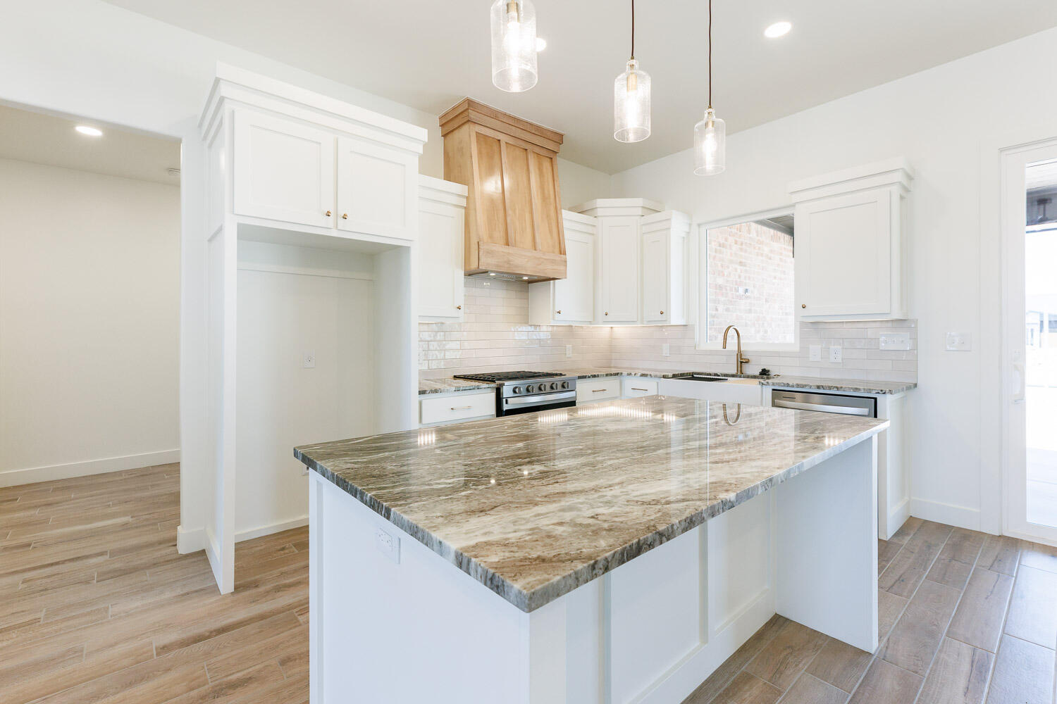 3634 144th Street Lubbock, TX 79423 - Photo 21 of 55 a kitchen with granite countertop a sink a center island and stainless steel appliances