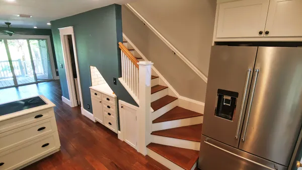 a view of a hallway with wooden floor and staircase