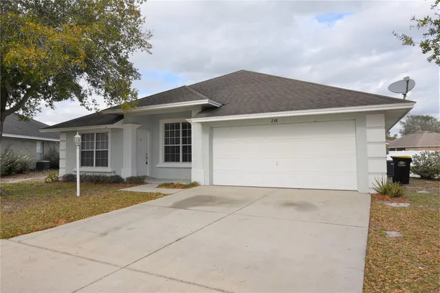 a front view of a house with a yard and a garage