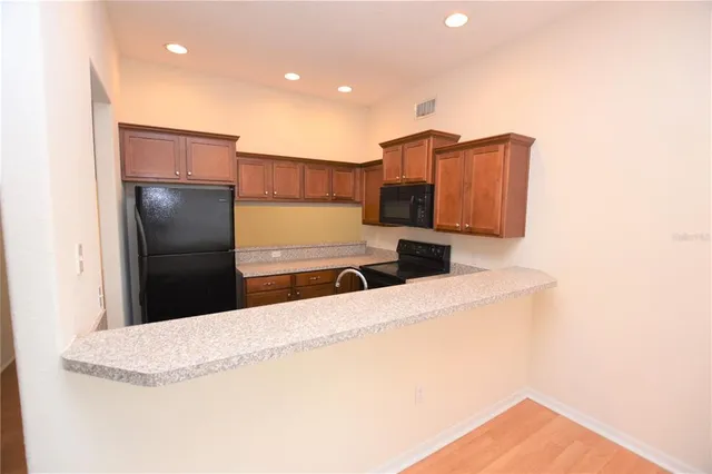 a kitchen with stainless steel appliances kitchen island a refrigerator sink and microwave