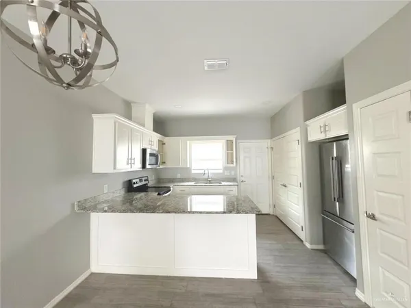 a kitchen with granite countertop a sink and steel appliances