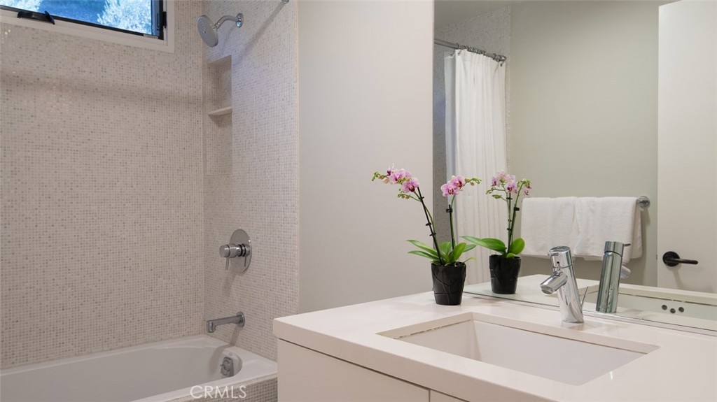 13501 Bayliss Road Brentwood, CA 90049 - Photo 17 of 24 a bathroom with a sink a bathtub and a mirror