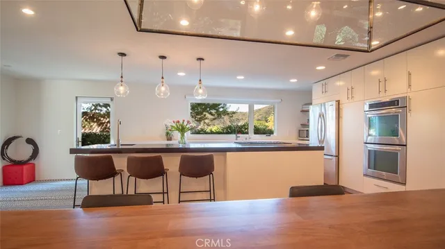 a view of kitchen with stainless steel appliances granite countertop center island a stove and a wooden floors