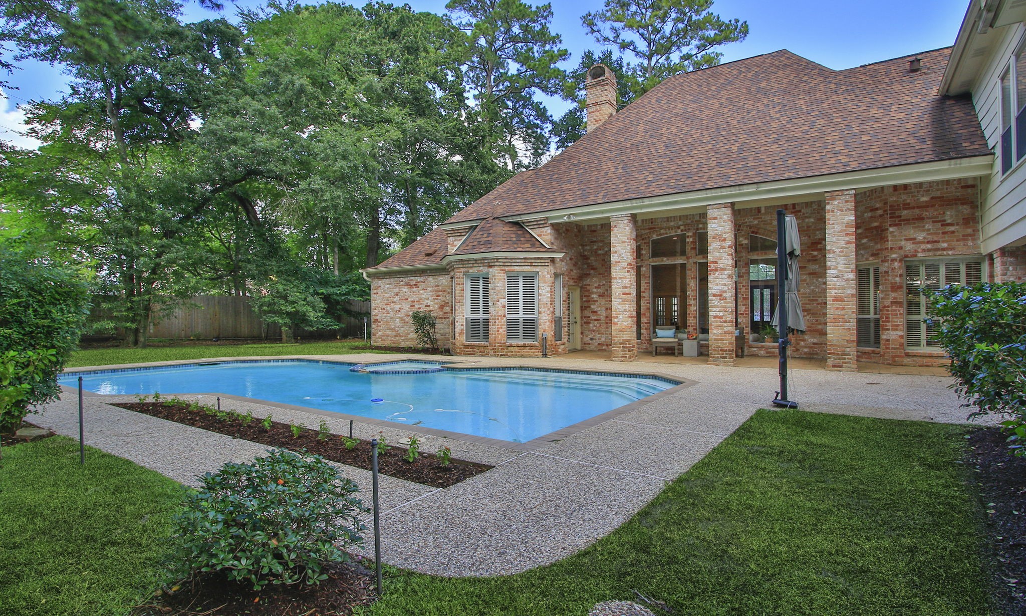 15923 Harwick Drive Spring, TX 77379 - Photo 48 of 50 Vacation doesn't require a plane ticket when you have a backyard like this! Enjoy a sparkling pool, beautiful landscaping, and two covered patios overlooking a private, tree-lined setting. Lots of shade for the Houston summers!