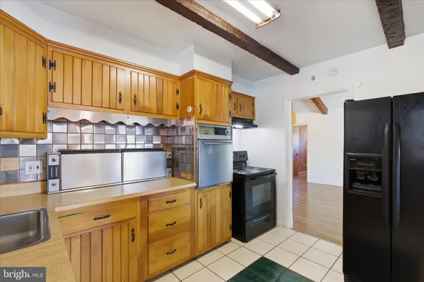 a kitchen with stainless steel appliances granite countertop a refrigerator a stove and a sink
