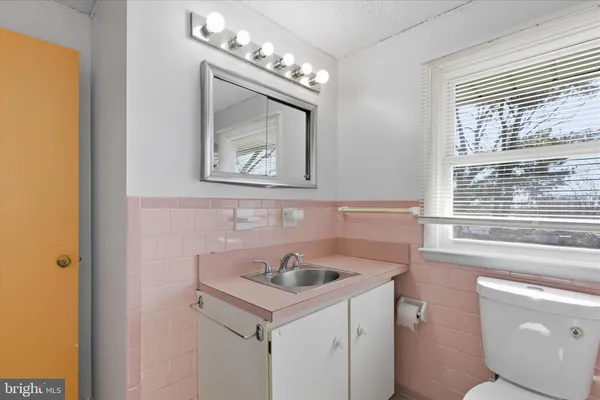 a bathroom with a sink and a large mirror next to a window