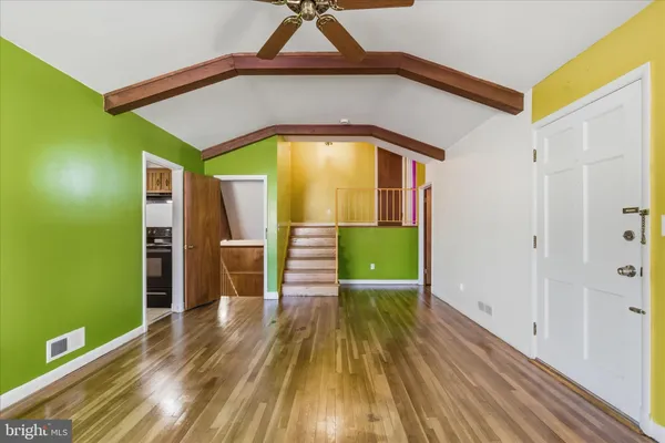 a view of a hallway with wooden floor and a sink
