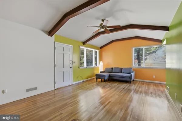 a living room with furniture and a wooden floor