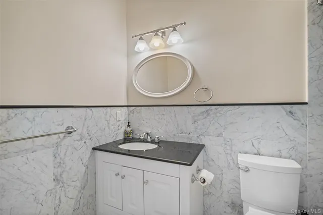 a bathroom with a sink a toilet and a mirror