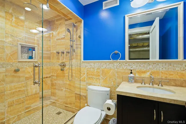 a bathroom with a sink a toilet and shower