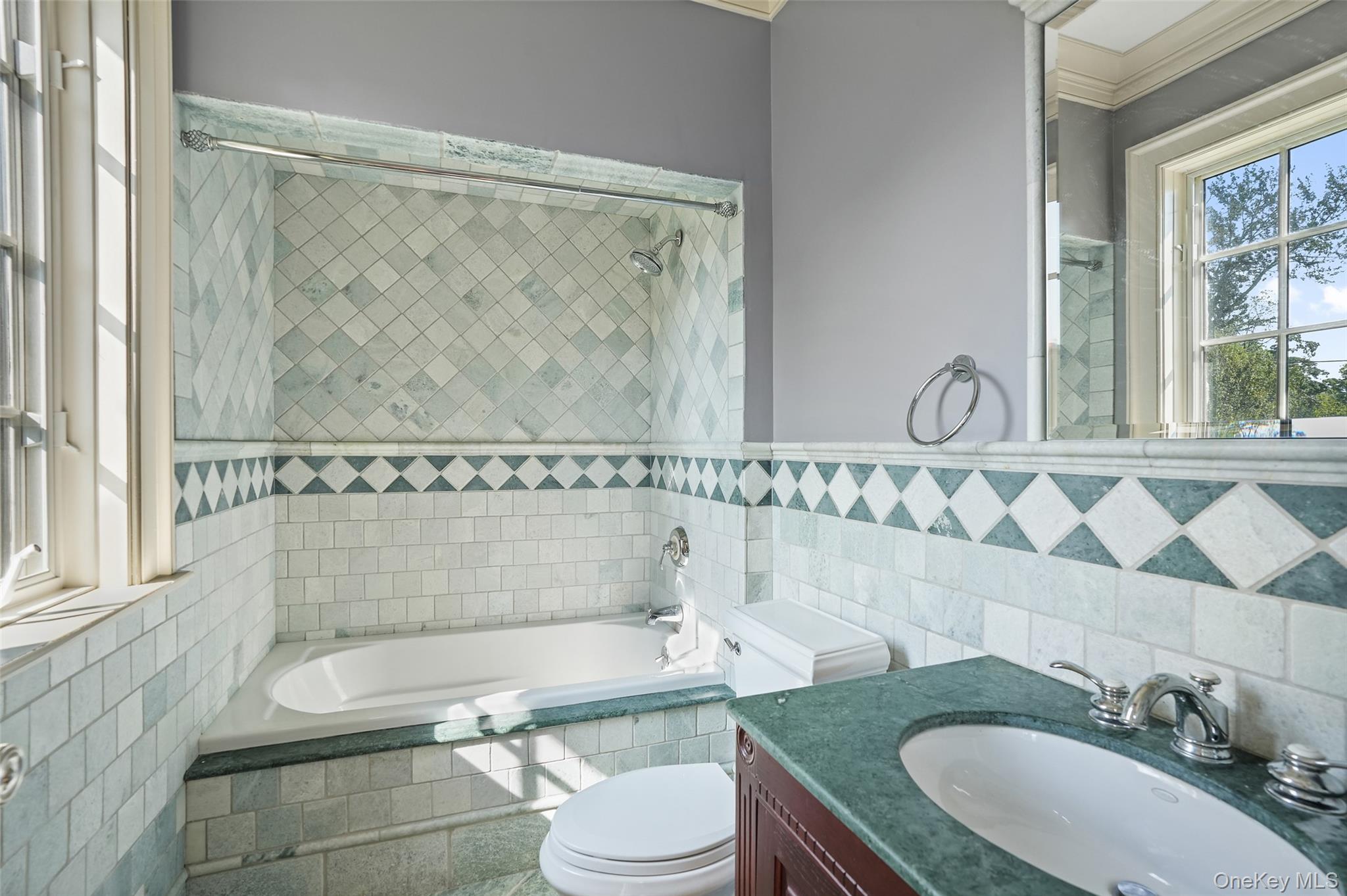 3747 Purchase Street Purchase, NY 10577 - Photo 37 of 48 Full bath featuring tiled shower / bath combo, tile walls, vanity, and ornamental molding