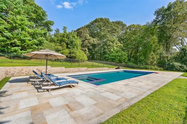 a view of a swimming pool with a table and chairs under an umbrella