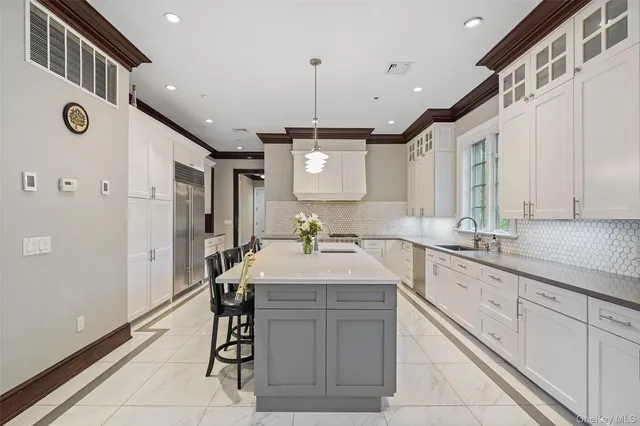 a large kitchen with a sink center island and stainless steel appliances