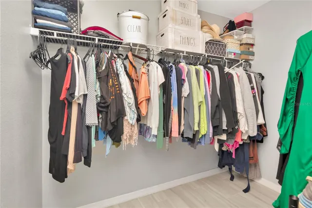 a view of walk in closet with clothes