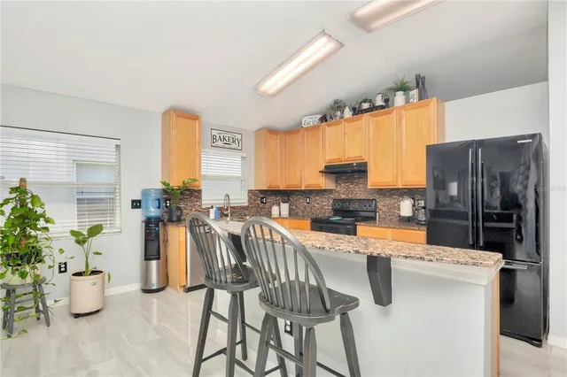 a kitchen with a sink refrigerator and microwave