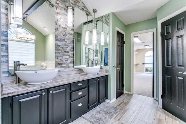 a spacious bathroom with a granite countertop sink and a mirror