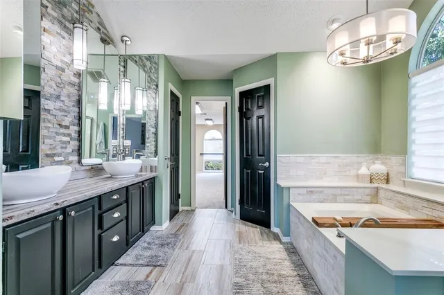 a spacious bathroom with a granite countertop sink a mirror and a shower