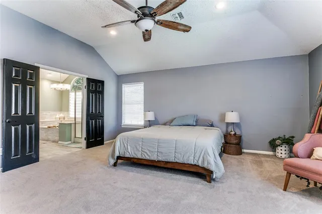 a bedroom with a bed chandelier and a window