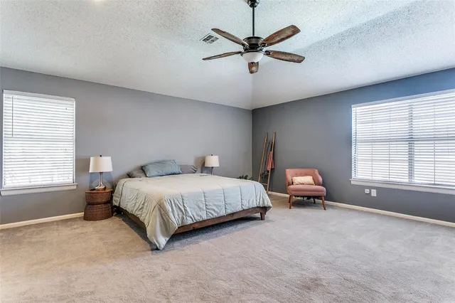 a spacious bedroom with a bed a chandelier and a window
