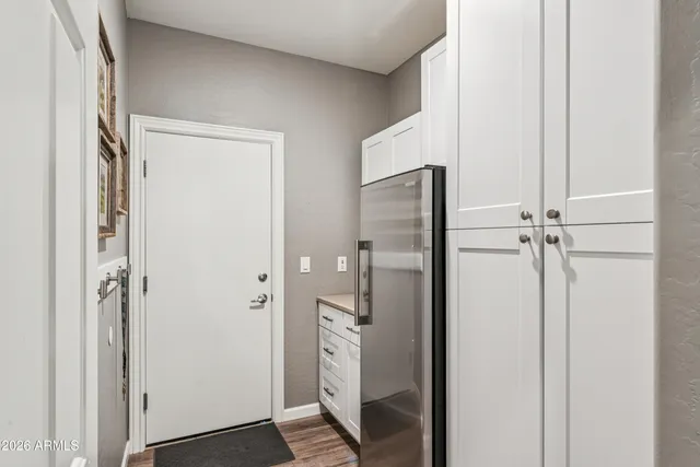a view of a hallway with a chair and potted plant