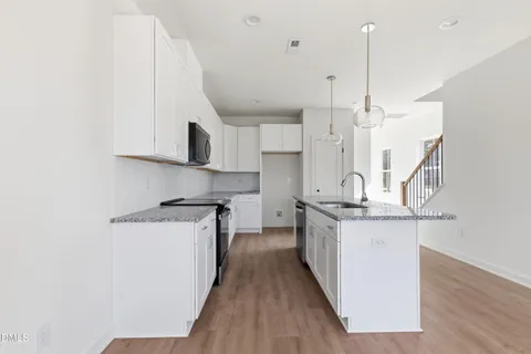 a view of a hallway with wooden floor and entryway