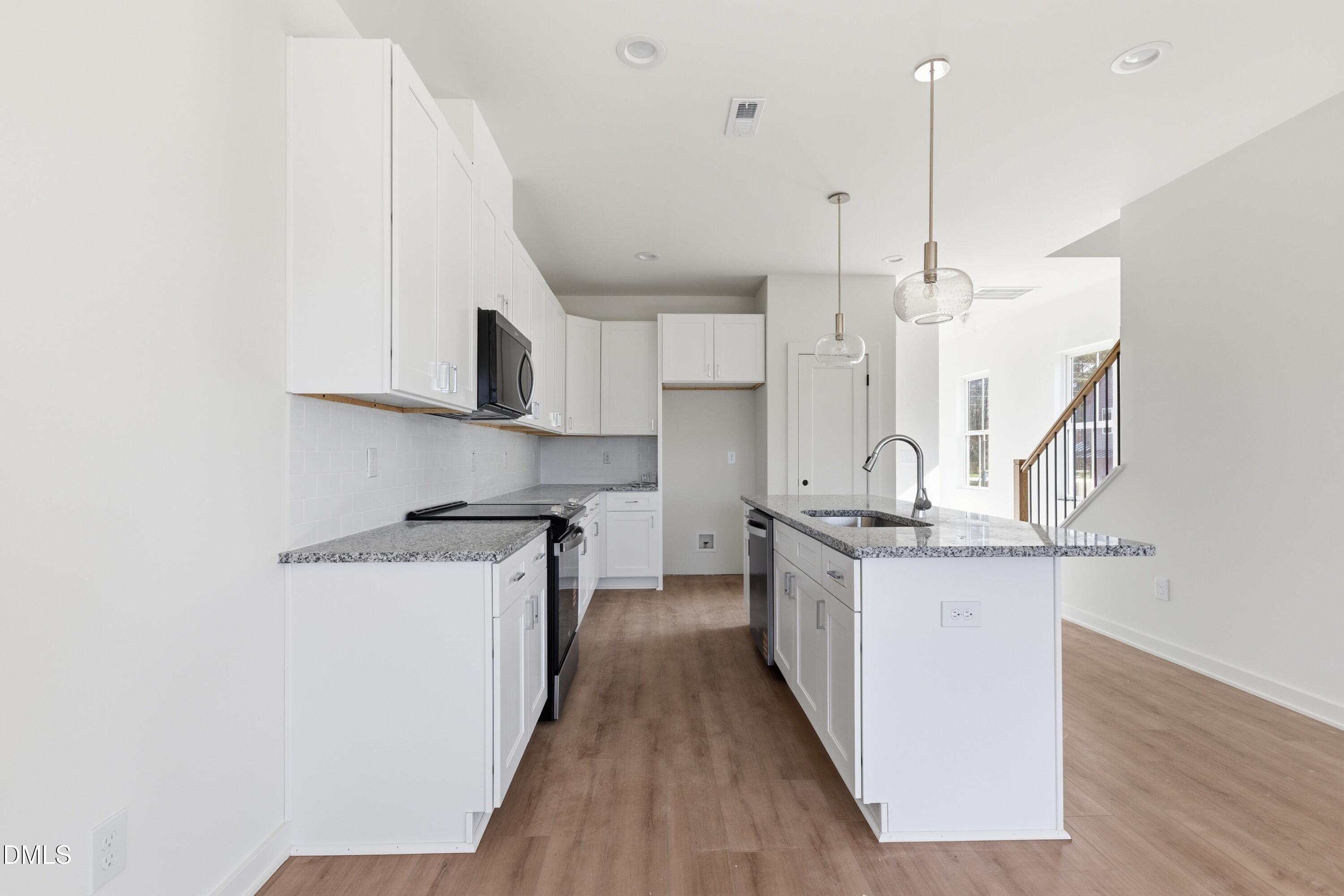 3814 Granite Mill Way Raleigh, NC 27616 - Photo 5 of 48 a kitchen with stainless steel appliances granite countertop a sink a stove and a wooden floors