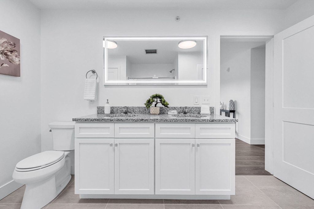 72 Central Street, Unit 407 Springfield, MA 01105 - Photo 20 of 25 a bathroom with a toilet a sink and mirror