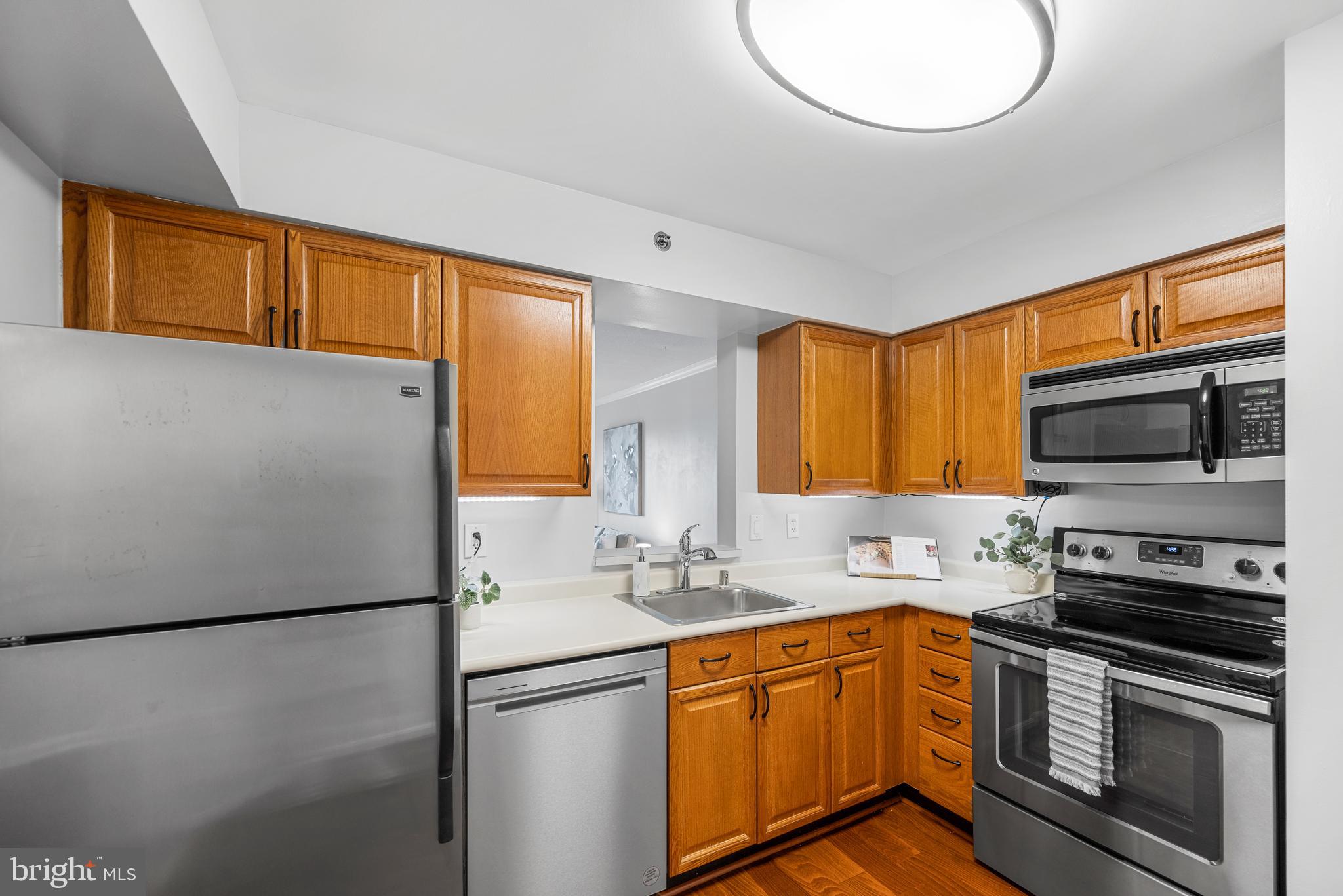 545 East Braddock Road, Unit 302 Alexandria, VA 22314 - Photo 10 of 36 a kitchen with stainless steel appliances granite countertop a refrigerator a stove a sink and a microwave