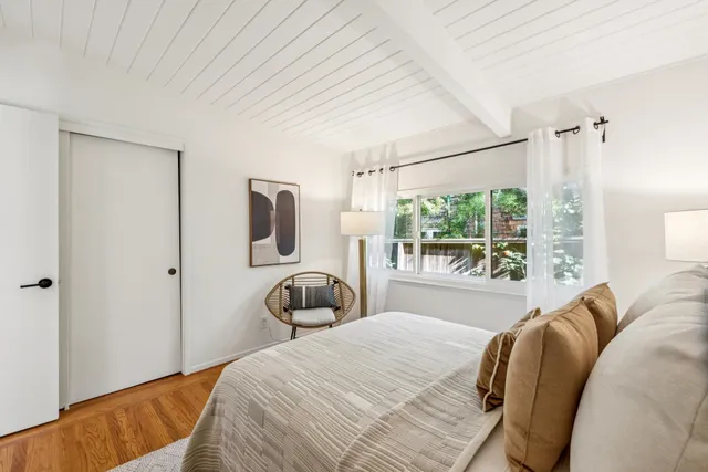 a bedroom with a bed and large window