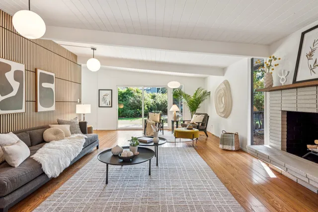 a living room with furniture a fireplace and a large window