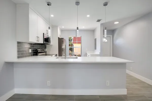 a view of kitchen with stainless steel appliances sink refrigerator and microwave