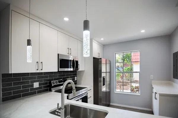 a kitchen with granite countertop a refrigerator and a sink