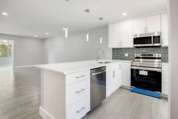 a kitchen with stainless steel appliances white cabinets and sink