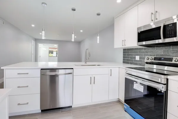 a kitchen with appliances a sink and cabinets