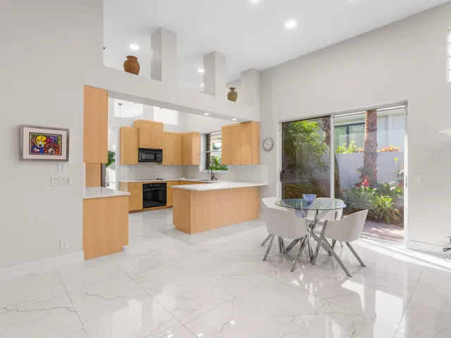 a large white kitchen with a large window and furniture