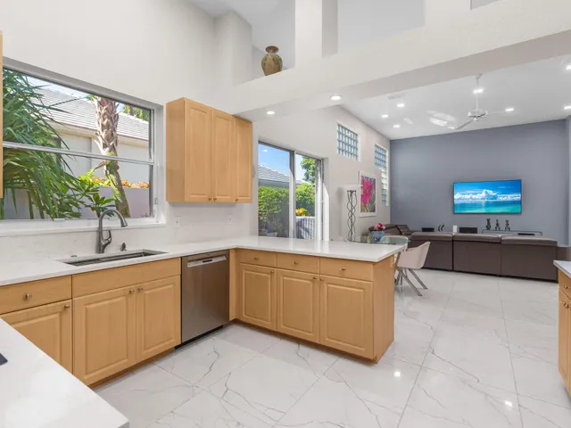 a large kitchen with stainless steel appliances kitchen island granite countertop a sink and a refrigerator