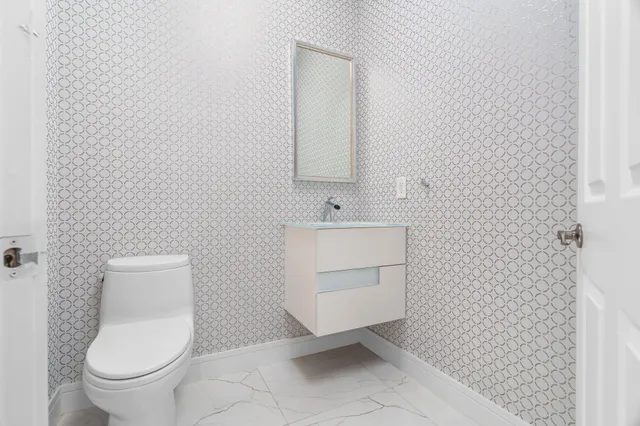 a bathroom with a toilet a sink and mirror